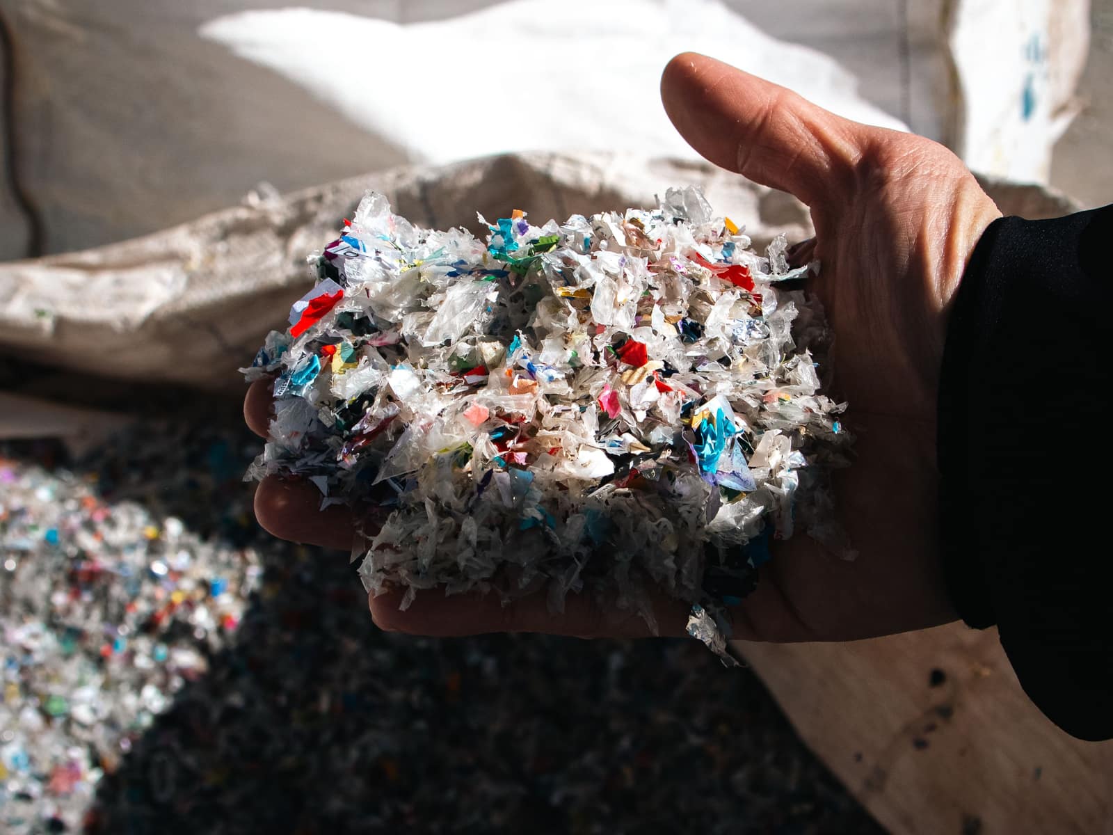 Molido de plástico reciclado en la palma de una mano